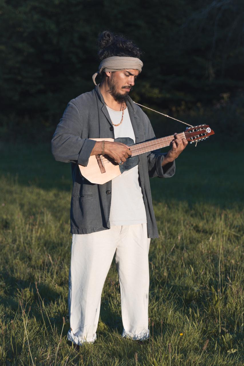 Daniel Cupiéd con su instrumento de cuerda al aire libre